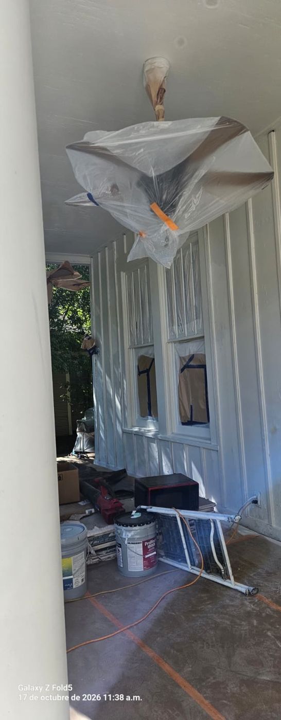 Porch with masked light fixture and painting supplies