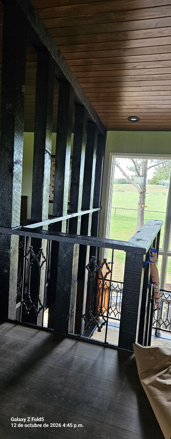Black painted loft railing with wood ceiling