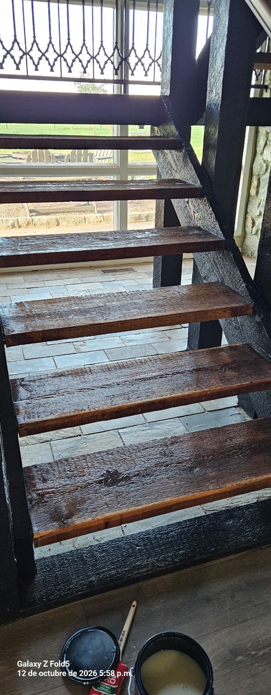 Stained wood stair treads with stain cans on the floor